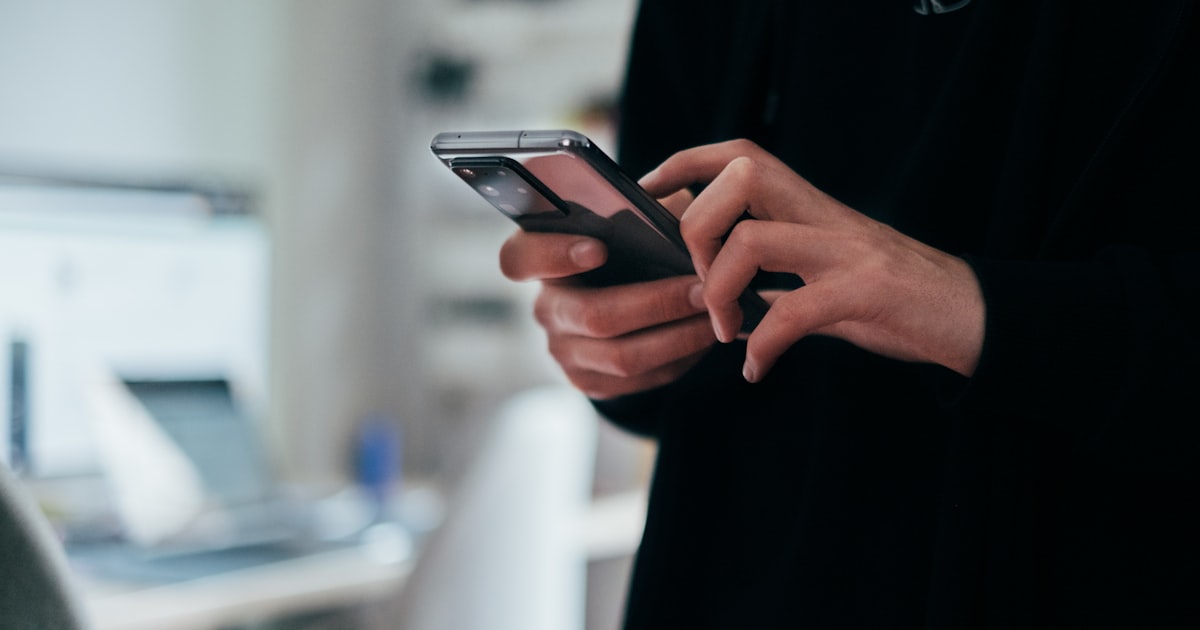 Personne tenant un smartphone, illustration de la réforme du démarchage téléphonique en France