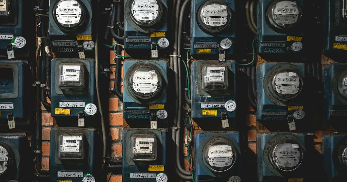 Rangée de compteurs électriques fixés sur un mur