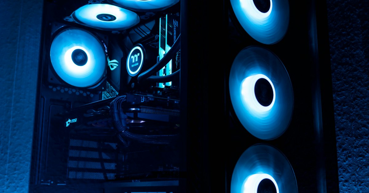 Boîtier de PC ouvert avec ventilateurs éclairés en bleu, matériel vendu par les revendeurs informatiques