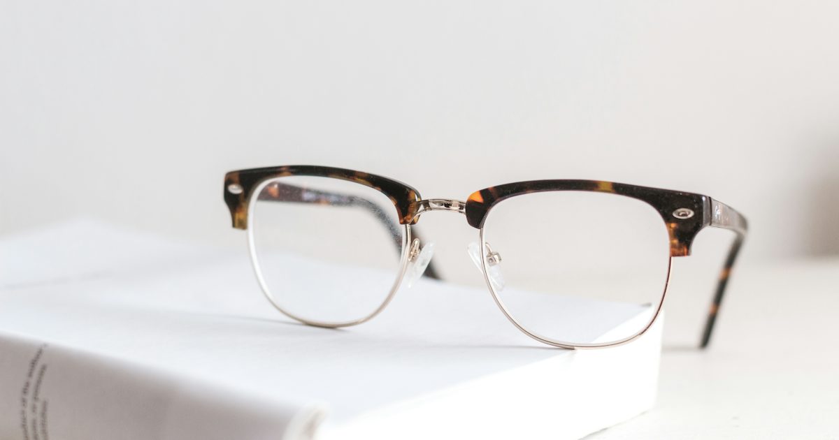 Paire de lunettes de vue posée sur un livre blanc