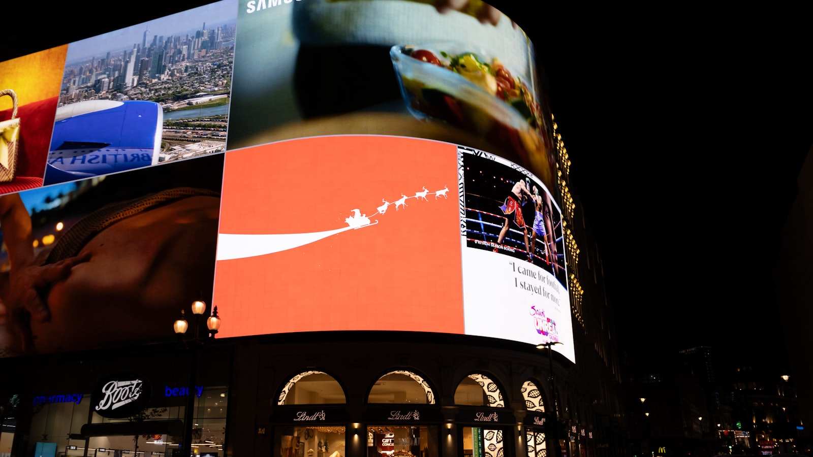 Écrans publicitaires géants allumés la nuit dans une rue commerçante, illustration du ciblage publicitaire permanent